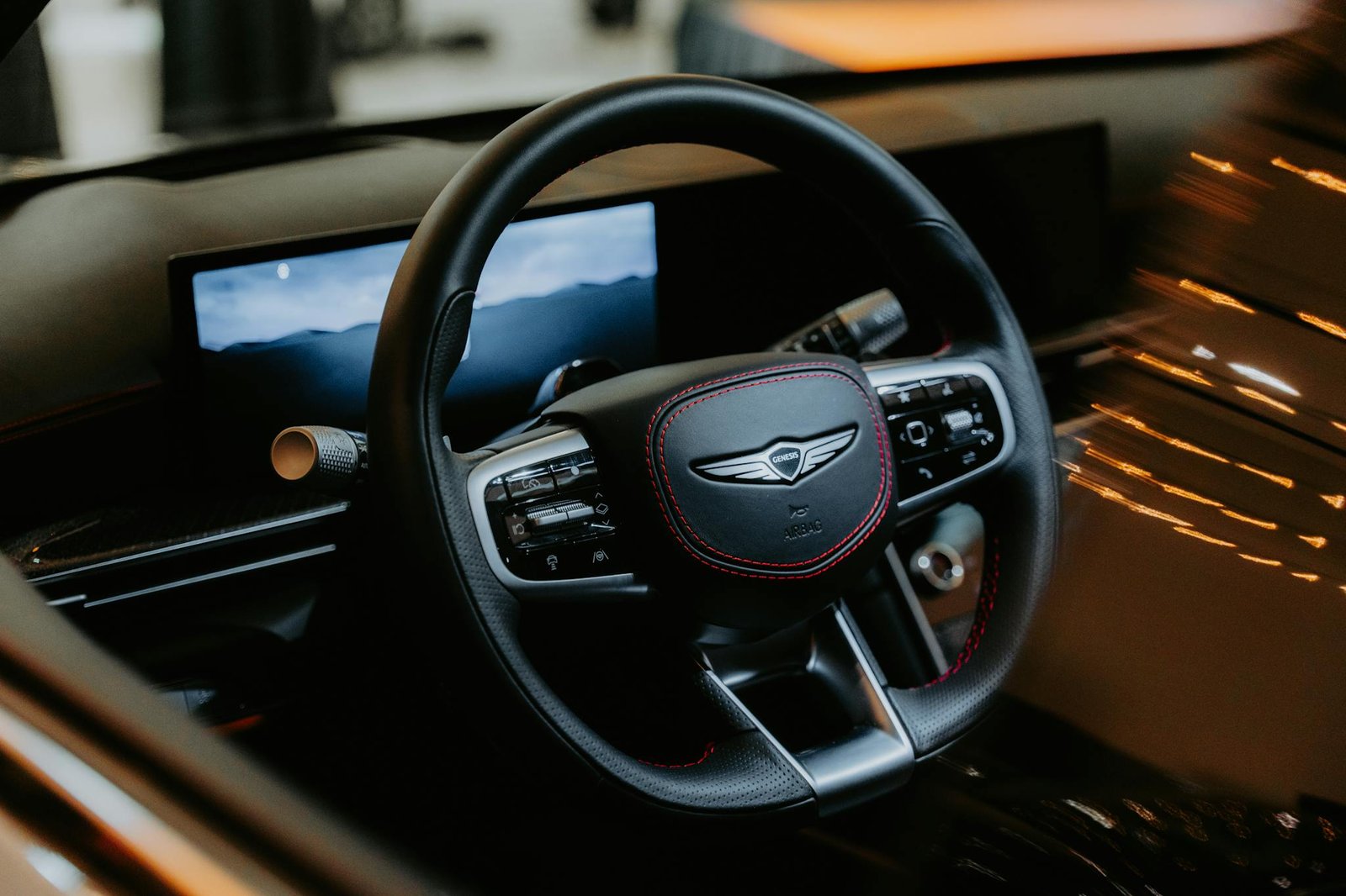 Close-up of a luxury car steering wheel with elegant design and advanced controls in a modern vehicle interior.